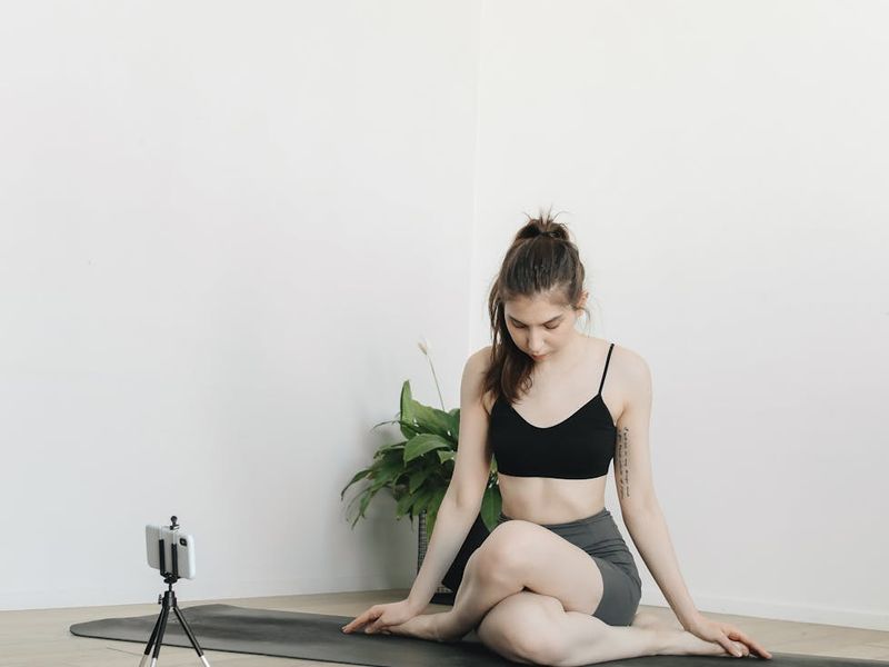Person in a focused yoga pose in a minimalist setting.